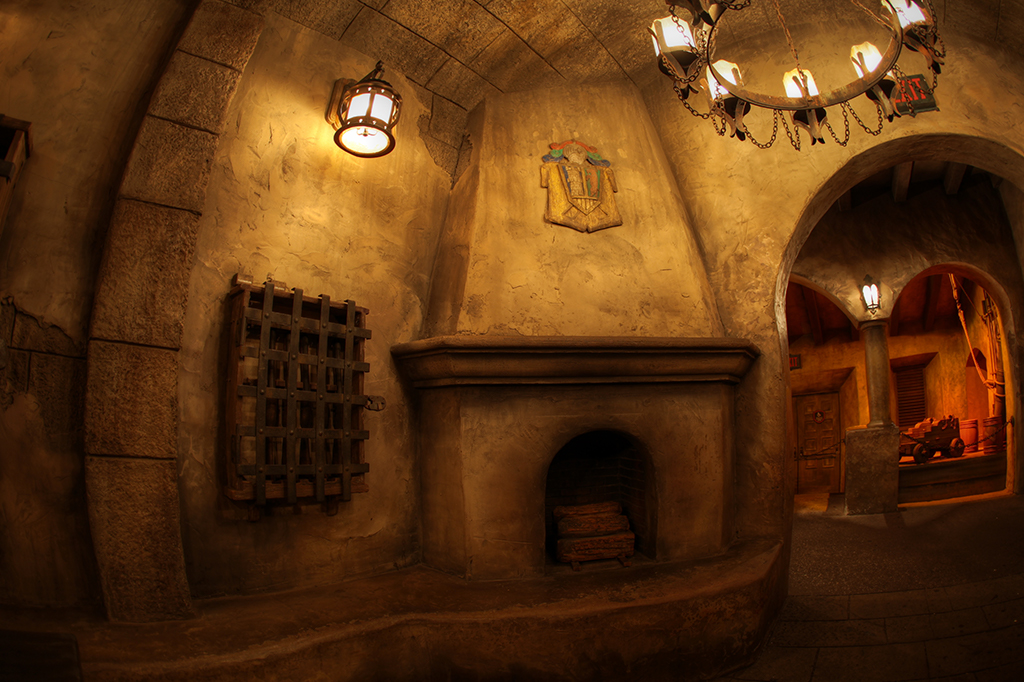 Stone fireplace and colonial architecture inside the Pirates of the Caribbean ride queue