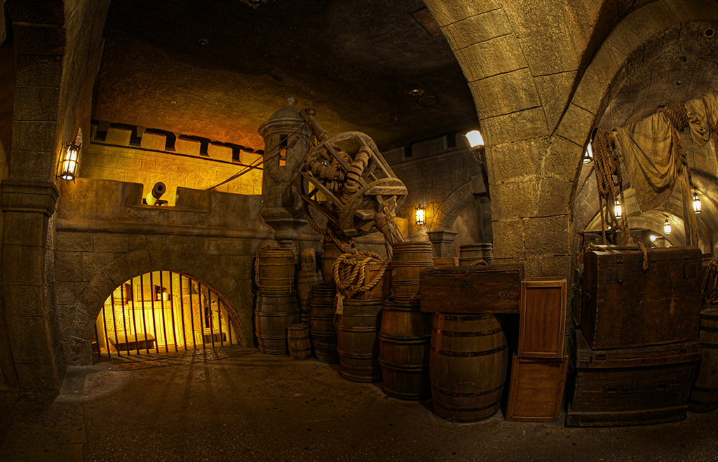 Pirates of the Caribbean ride queue featuring barrels, crates, and a crow's nest